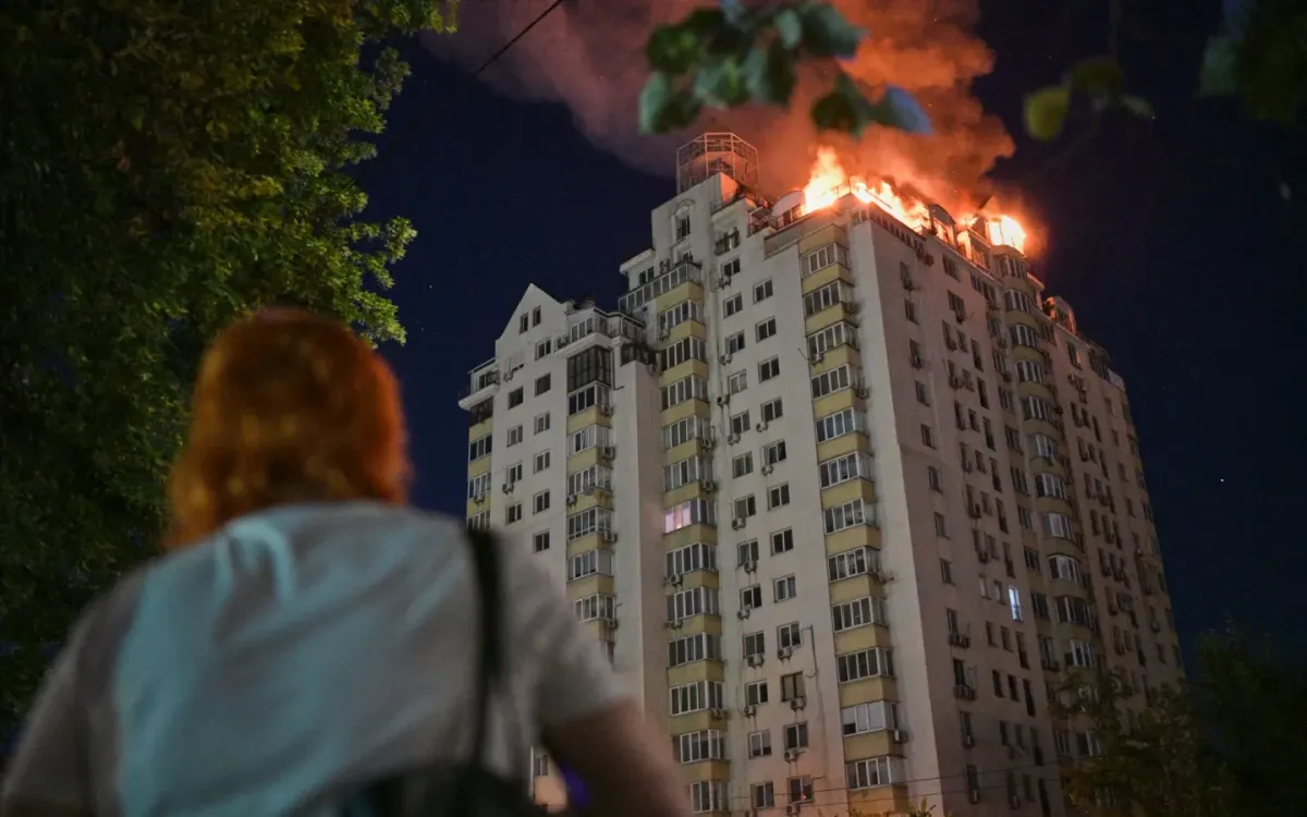 Một phụ nữ nhìn tòa chung cư bốc cháy sau vụ tấn công tên lửa tại Kiev, Ukraine, ngày 2/7/2026. (Ảnh: AP)