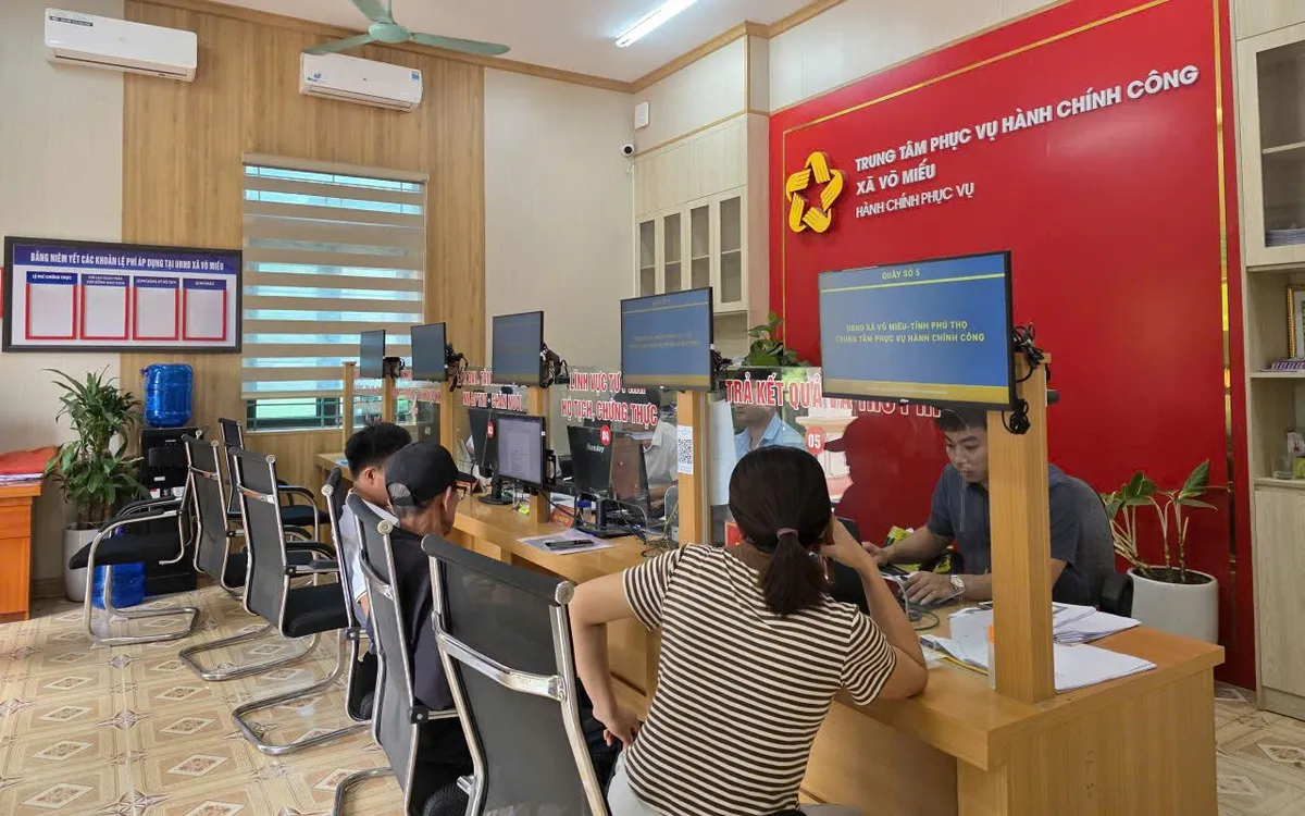 Cán bộ hướng dẫn người dân làm thủ tục tại Trung tâm hành chính công xã Võ Miếu. Ảnh: Thu Hường