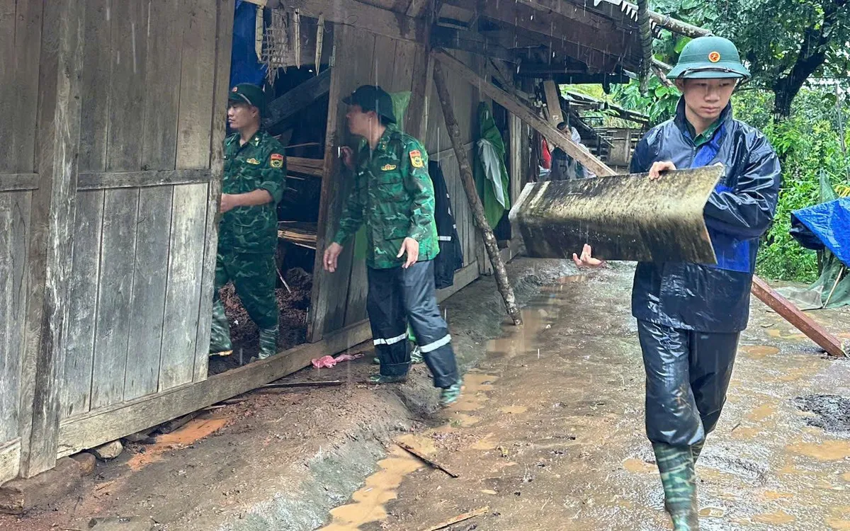 Cán bộ, chiến sĩ Đồn Biên phòng Dào San khẩn trương hỗ trợ người dân di dời tài sản ra khỏi khu vực có nguy cơ sạt lở để bảo đảm an toàn. Ảnh: Đức Duẩn