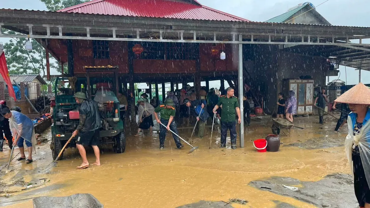 Lào Cai hỗ trợ người dân dọn dẹp bùn đất tràn vào nhà sau lũ - Ảnh 2.