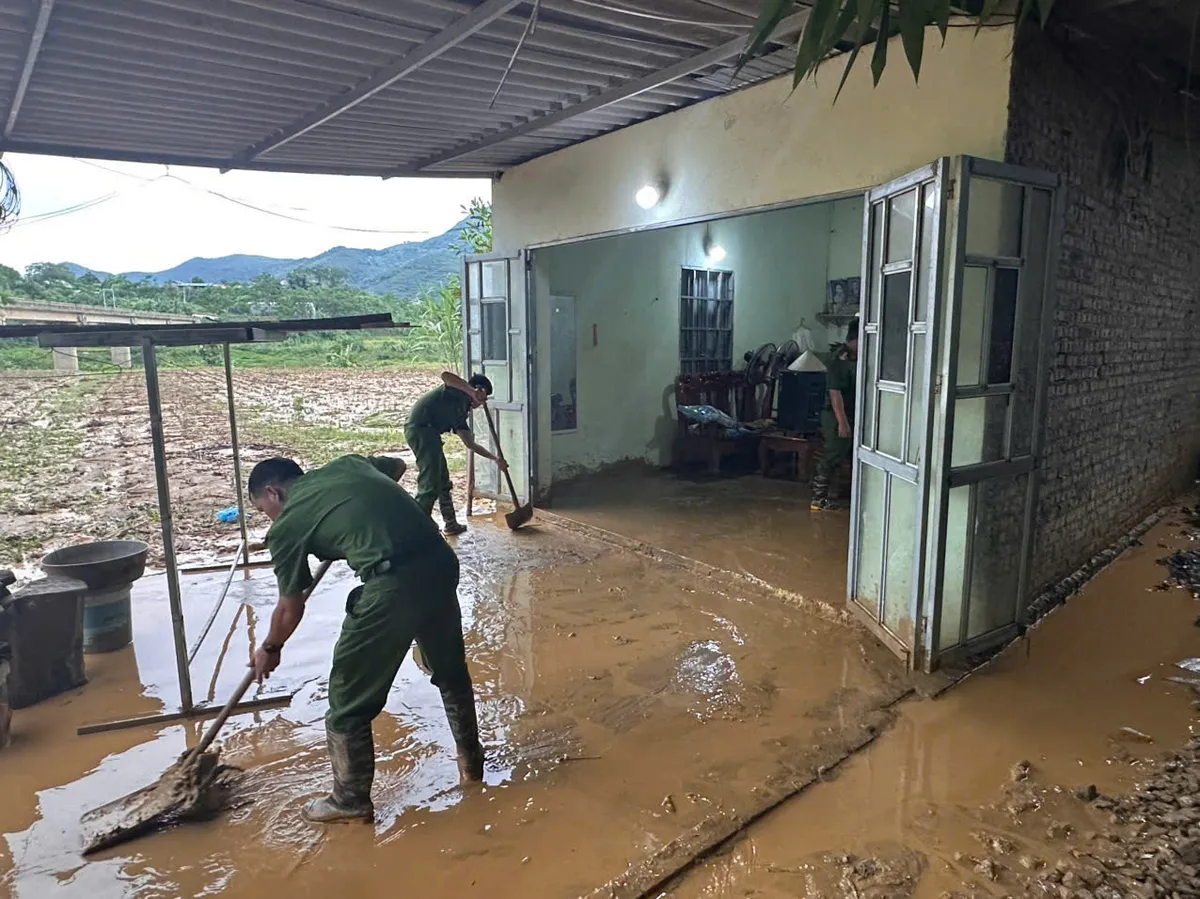 Lào Cai hỗ trợ người dân dọn dẹp bùn đất tràn vào nhà sau lũ - Ảnh 4.