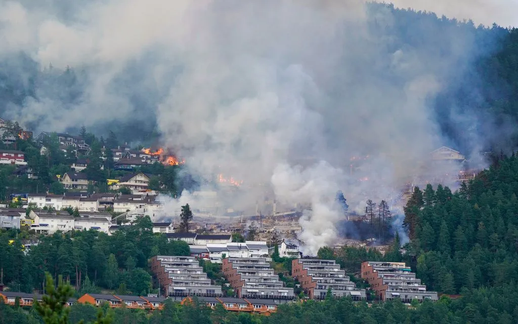 Khói bốc lên từ dãy nhà liền kề bị cháy tại làng Krokstadelva, thành phố Drammen, Na Uy, ngày 17/7/2026 (Ảnh: AP)