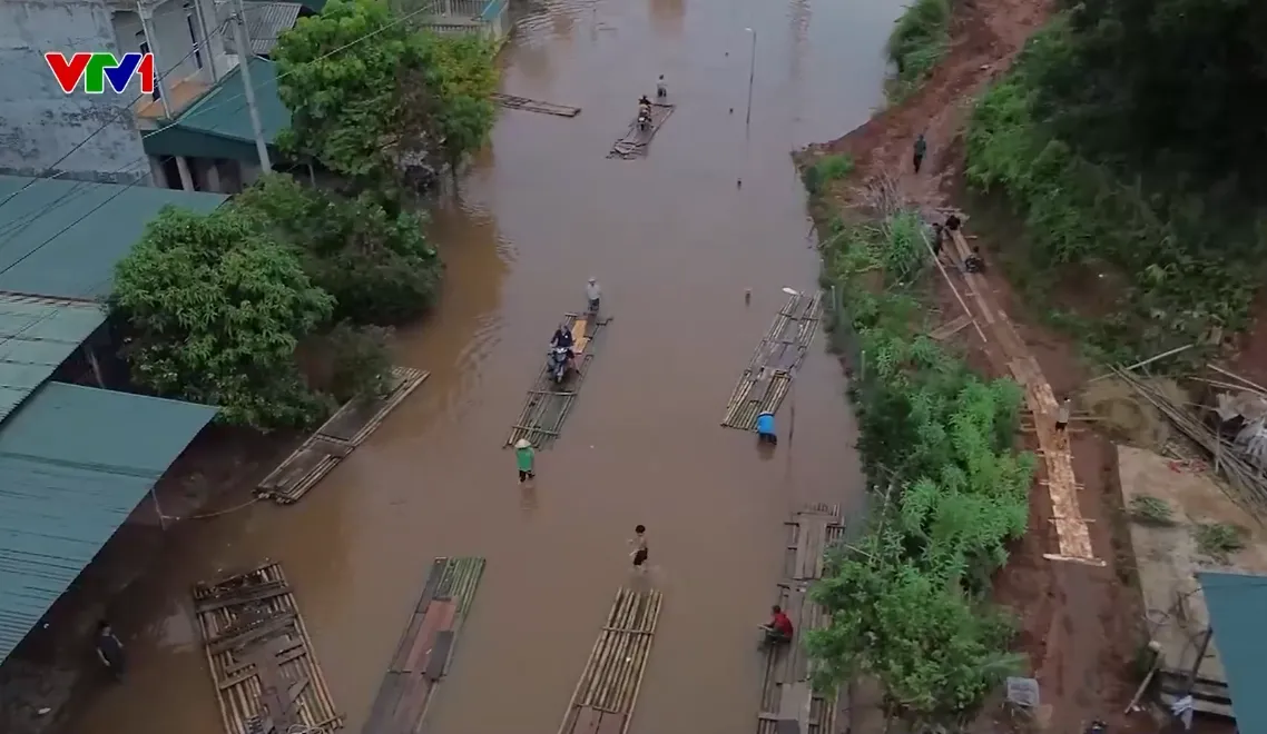 Người dân chế mảng, làm cầu phao bằng tre di chuyển qua đoạn ngập sâu trên Quốc lộ 279 - Ảnh 1.