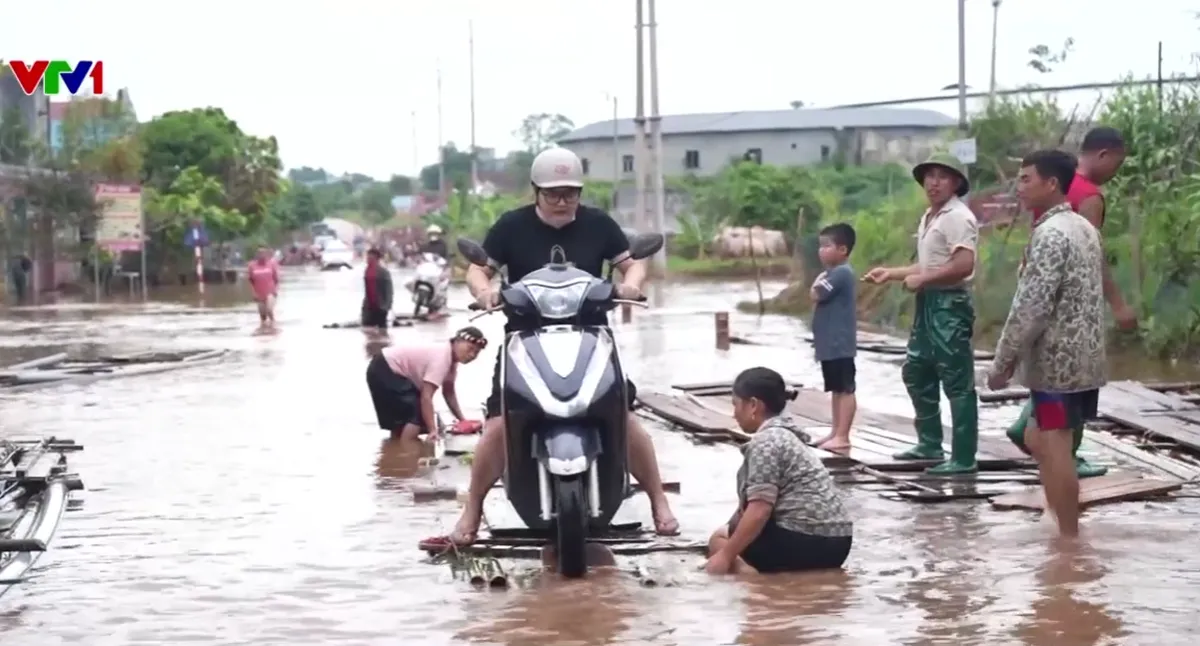 Quốc lộ 279 ngập gần 3 tuần, người dân phải đi bè qua đoạn đường huyết mạch- Ảnh 1.