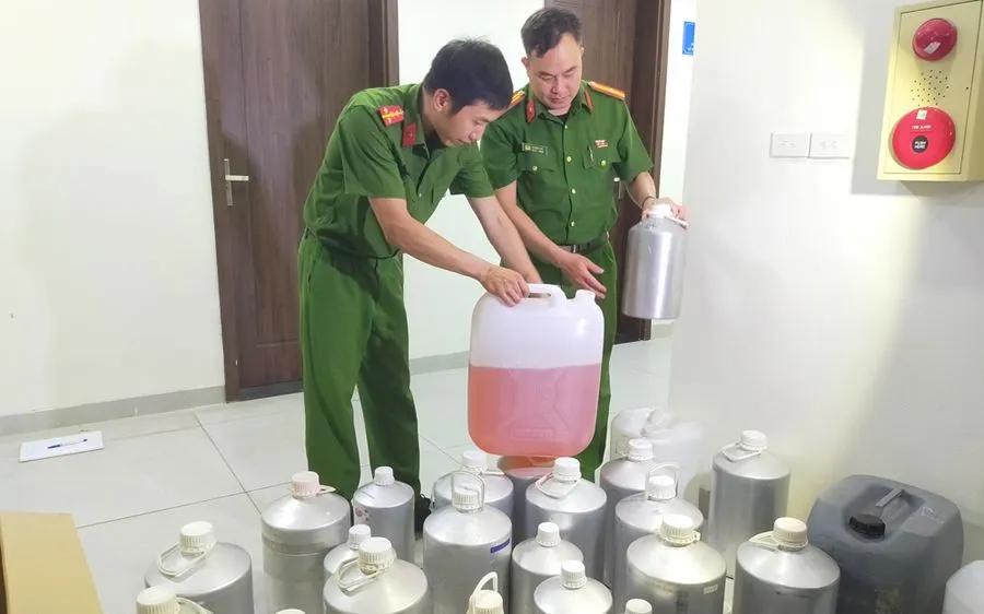 Những can hương liệu và nước hoa giả được các đối tượng sử dụng để pha chế, sang chiết nước hoa giả mang các thương hiệu nổi tiếng. (Ảnh: Bộ Công an)