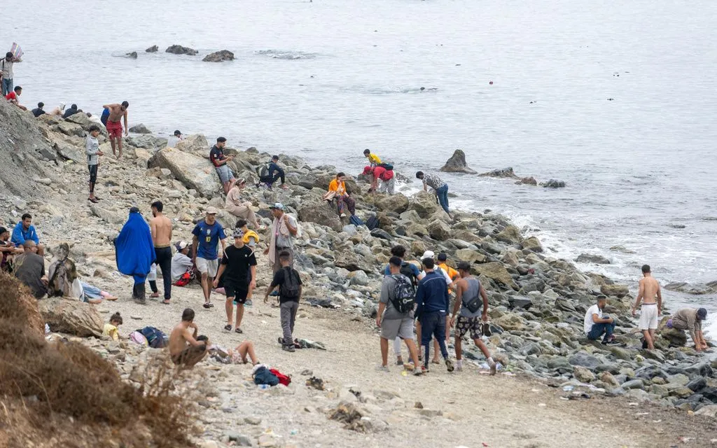Người di cư đi dọc bãi biển ở Fnideq, Maroc, tìm cách vượt sang Ceuta, Tây Ban Nha, ngày 31/7/2026 (Ảnh: AP)