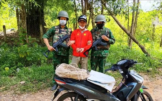 Đối tượng Trương Quốc Phong (sinh năm 1990, trú xã Lao Bảo, tỉnh Quảng Trị) cùng tang vật tại hiện trường. Ảnh: TTXVN