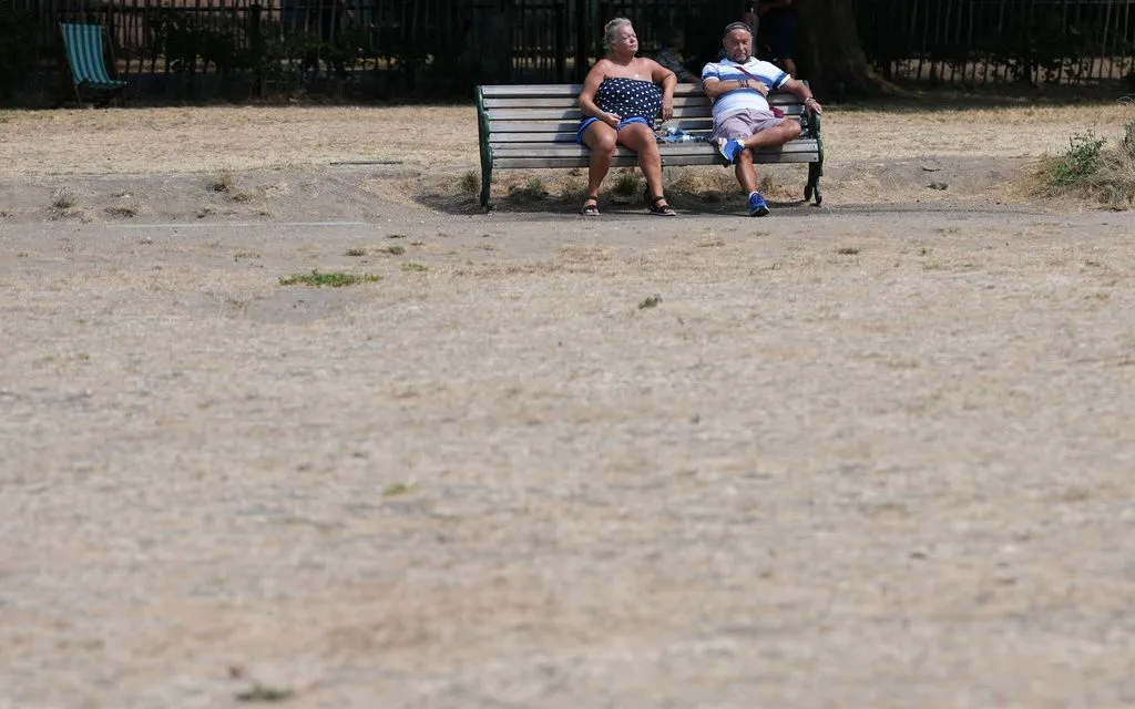 Người dân ngồi giữa thảm cỏ khô tại Green Park ở London, Anh, ngày 3/8/2026. (Ảnh: AP/Kirsty Wigglesworth)