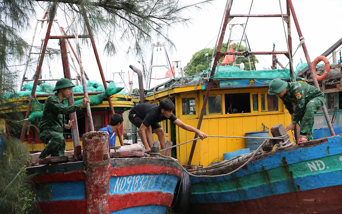 Lực lượng chức năng hỗ trợ ngư dân neo đậu, gia cố tàu thuyền, chủ động ứng phó với diễn biến phức tạp của thời tiết. Ảnh: KC