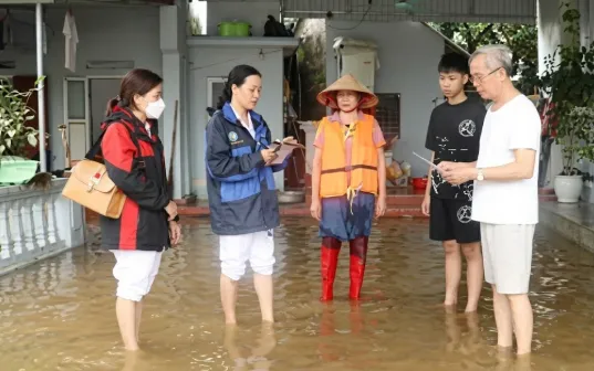 Nhân viên y tế hướng dẫn người dân vệ sinh phòng bệnh sau lũ lụt. Ảnh: HCDC