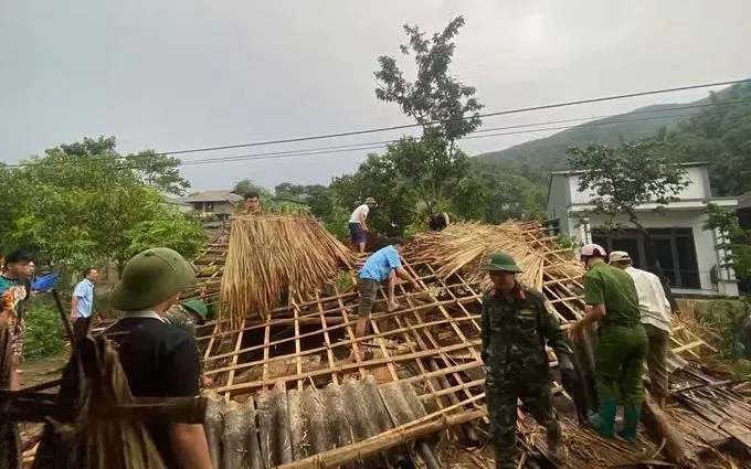 Lực lượng chức năng hỗ trợ người dân xã Dương Quỳ khắc phục hậu quả thiên tai. Ảnh: TTXVN