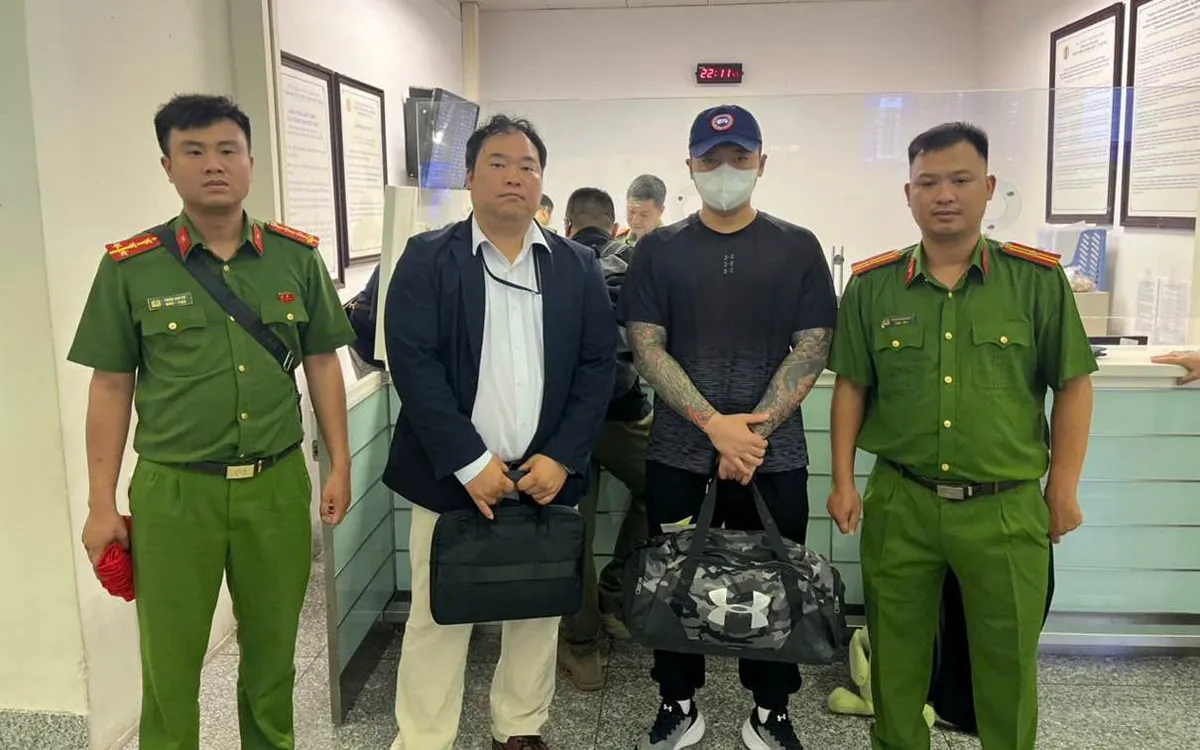 Lực lượng công an bàn giao đối tượng Lee Sammin cho phía Hàn Quốc (áo đen, đứng thứ 3 từ trái sáng). Ảnh: Công an TP Hà Nội