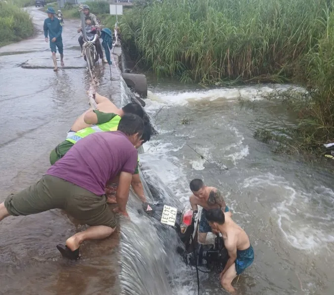 Cứu người dân đi xe máy bị nước lũ cuốn trôi ở Đắk Lắk - Ảnh 2.