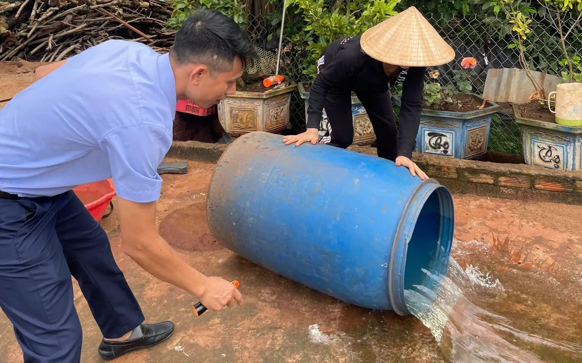 Trung tâm Kiểm soát bệnh tật tỉnh Đắk Lắk hướng dẫn người dân lật đổ các dụng cụ chứa nước có nhiều lăng quăng, bọ gậy. Ảnh: Sở Y tế Đắk Lắk