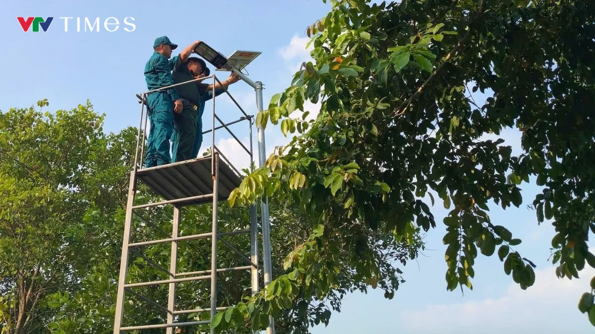 Cán bộ, chiến sĩ Ban CHQS xã Hiển Khánh cùng các lực lượng lắp đặt hệ thống đèn năng lượng mặt trời trên tuyến đường quê. Ảnh: XHK