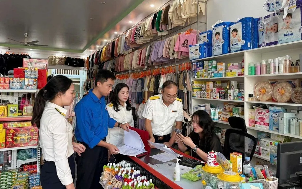 Cán bộ thuế hướng dẫn hộ kinh doanh trong quá trình kê khai thuế. Ảnh: Dương Hải/BNEWS/TTXVN
