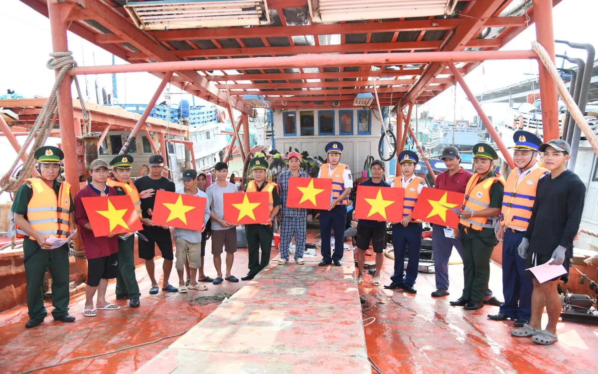 Cảnh sát biển và Biên phòng trao tặng cờ Tổ quốc cho bà con ngư dân, động viên vững tâm vươn khơi bám biển.
