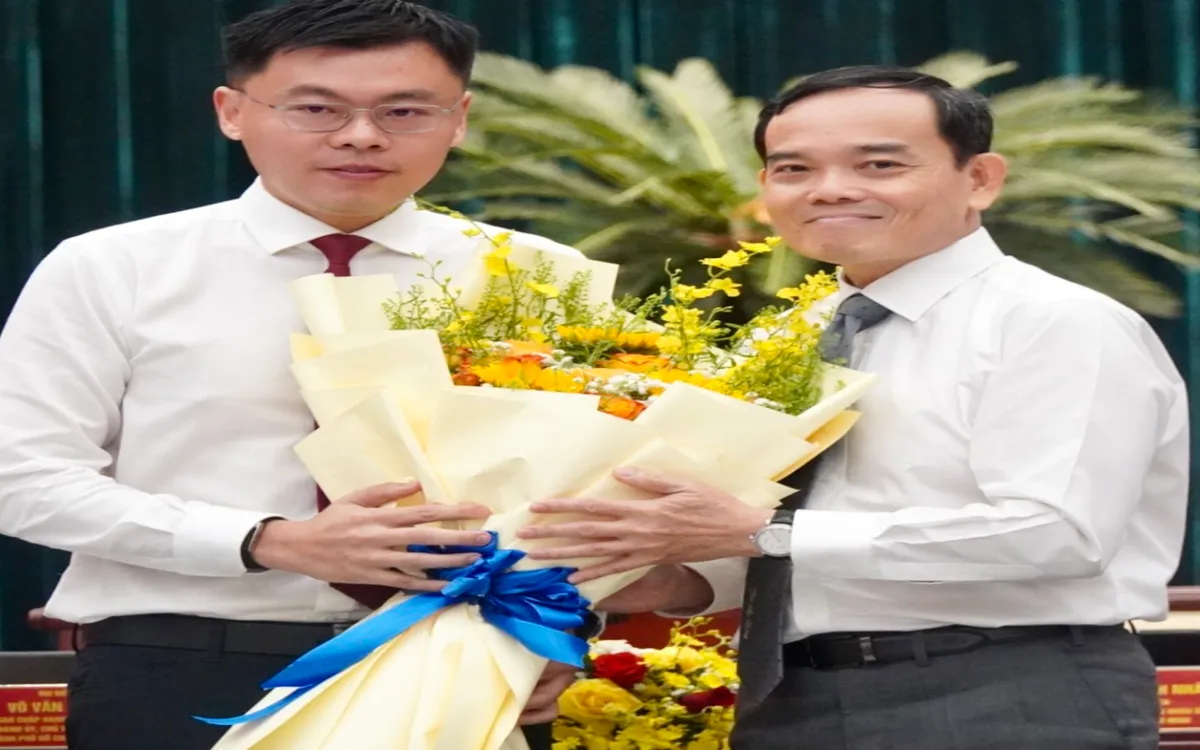 Bí thư Thành uỷ TP Hồ Chí Minh Trần Lưu Quang tặng hoa chúc mừng tân Phó Chủ tịch UBND Thành phố Trương Minh Huy Vũ  Ảnh: Thu Trang