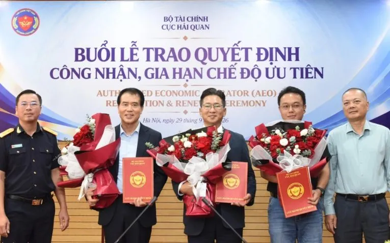 Phó Cục trưởng Cục Hải quan Trần Đức Hùng (bên trái) và Cục trưởng Cục Xuất nhập khẩu (Bộ Công Thương) Nguyễn Anh Sơn trao quyết định, tặng hoa cho 3 doanh nghiệp được công nhận doanh nghiệp ưu tiên. Ảnh: Thái Bình.