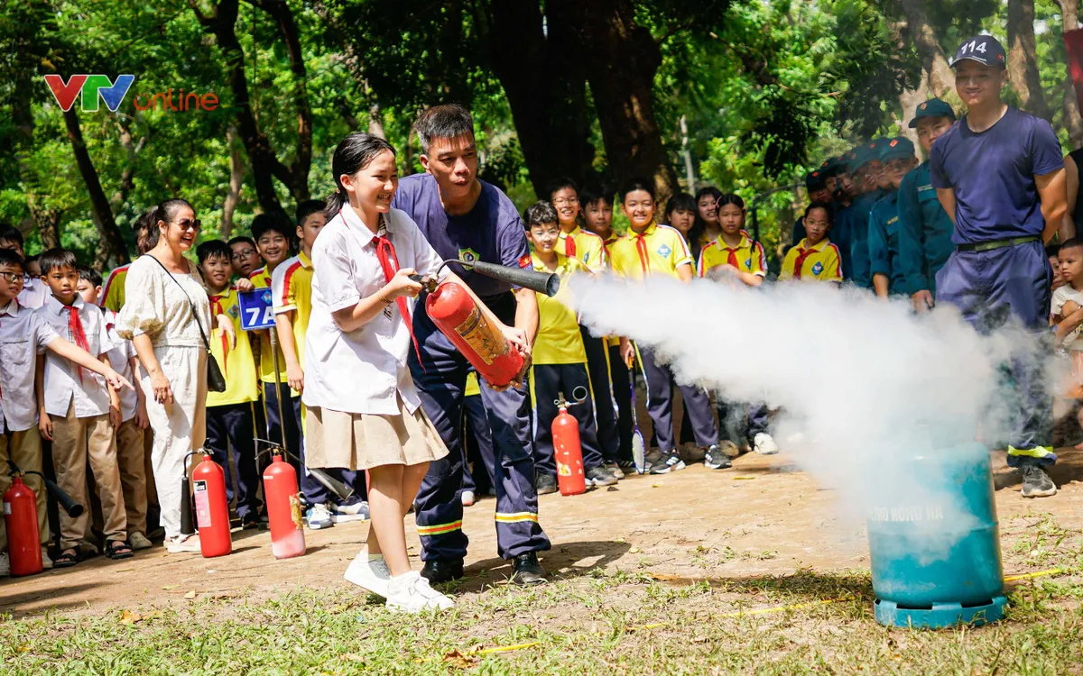 Thiếu tá Trần Mạnh Thắng (Đội Cảnh sát PCCC và CNCH khu vực 9) hướng dẫn học sinh thực hành kỹ năng PCCC. (ảnh: Lô Giang)