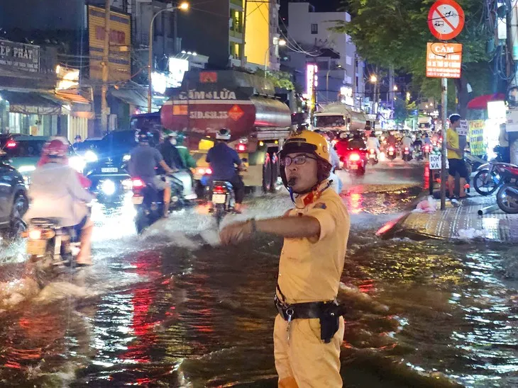 CSGT TP Hồ Chí Minh khuyến cáo giảm tốc độ, không cố vượt vùng ngập sâu khi mưa lớn - Ảnh 1.