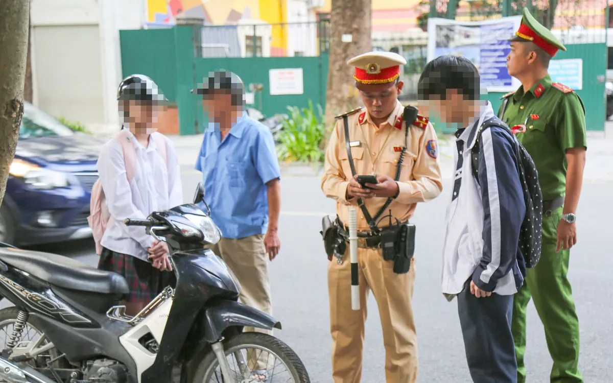 Lực lượng chức năng tăng cường kiểm soát vi phạm giao thông của học sinh tại khu vực cổng trường.