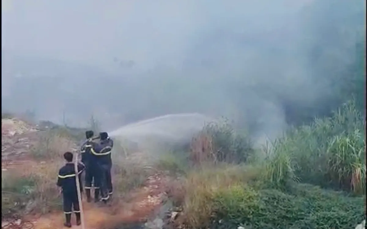 Lực lượng chức năng và các phương tiện chữa cháy xử lý đám cháy tại bãi rác tạm. Ảnh: UBND phường Vĩnh Phúc 