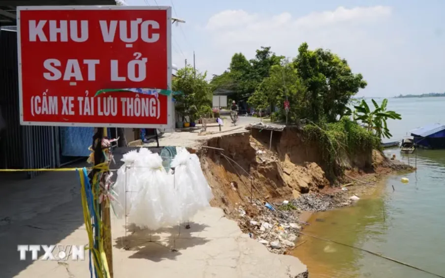 Biển cảnh báo đặt tại một điểm sạt lở bờ sông Tiền. (Ảnh: TTXVN)