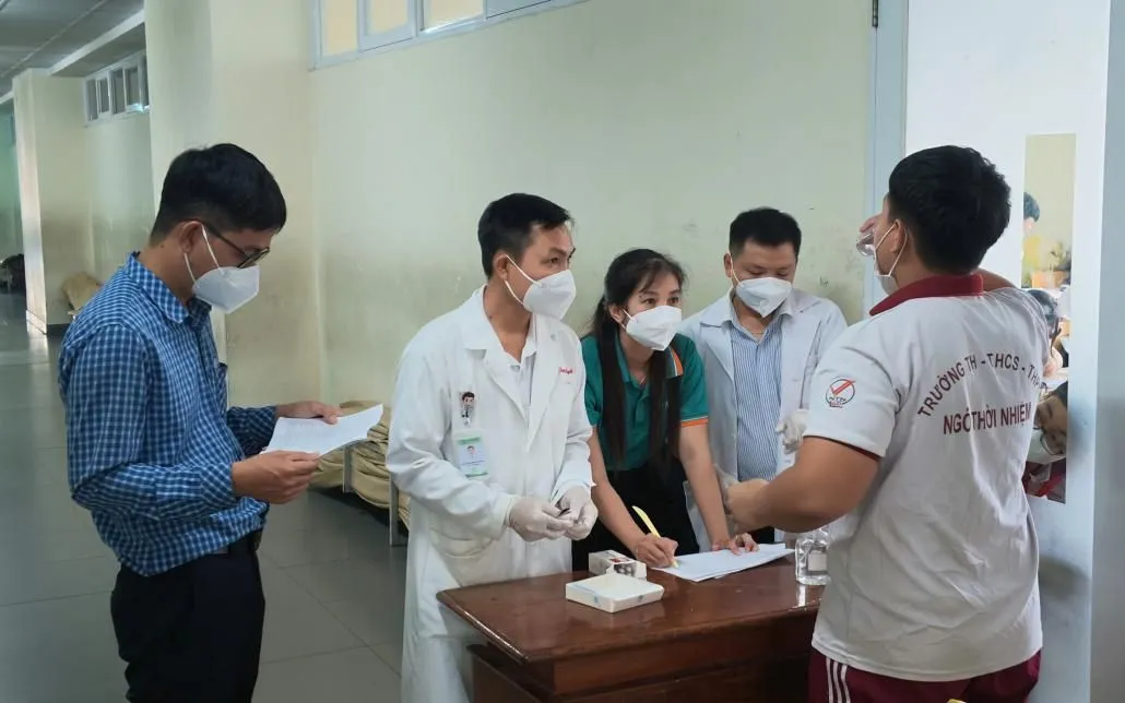 Các học sinh tiếp xúc gần với ca bệnh tại Trường TH-THCS-THPT Ngô Thời Nhiệm, phường Bình Dương được uống kháng sinh dự phòng. Ảnh: HCDC