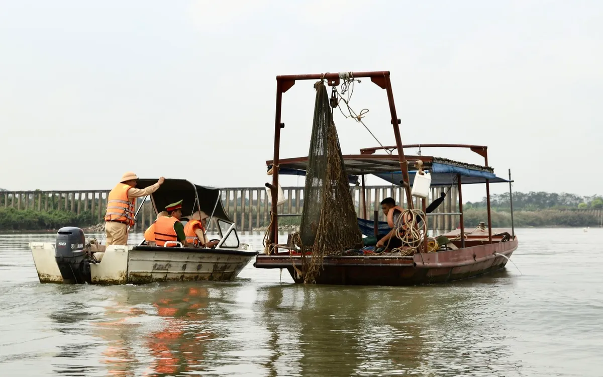 Ca nô của lực lượng Cảnh sát đường thủy thực hiện công tác tuyên truyền, nhắc nhở ngư dân trên sông Hồng.