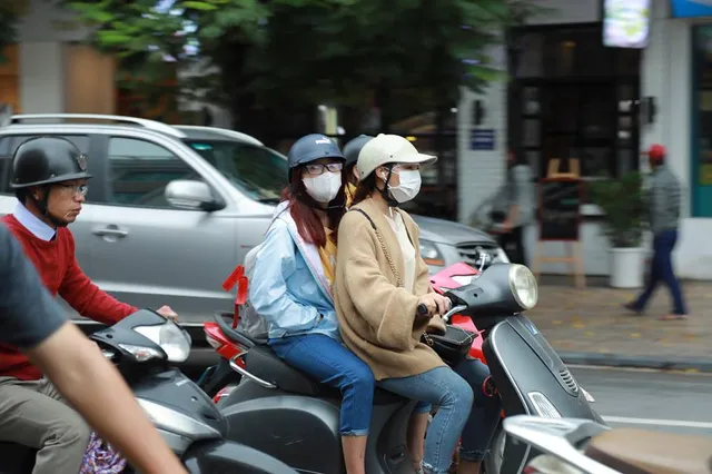 Người dân Hà Nội co ro trong gió lạnh đầu mùa - Ảnh 2. Người dân Hà Nội co ro trong gió lạnh đầu mùa - Ảnh 2.