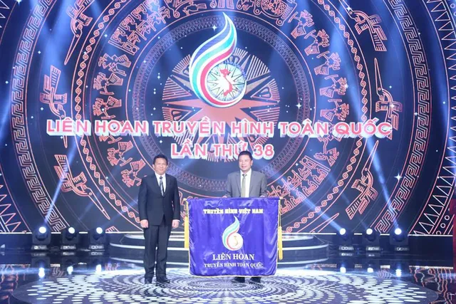 Ông Nguyễn Tấn Lộc, Giám đốc Đài PT-TH Lâm Đồng, Trưởng ban Tổ chức Liên hoan Truyền hình toàn quốc lần thứ 38 lên sân khấu trao cờ luân lưu cho ông Lê Anh Vũ - Giám đốc Đài PT-TH Khánh Hòa, đơn vị đăng cai tổ chức LHTHTQ lần thứ 39. Ông Nguyễn Tấn Lộc, Giám đốc Đài PT-TH Lâm Đồng, Trưởng ban Tổ chức Liên hoan Truyền hình toàn quốc lần thứ 38 lên sân khấu trao cờ luân lưu cho ông Lê Anh Vũ - Giám đốc Đài PT-TH Khánh Hòa, đơn vị đăng cai tổ chức LHTHTQ lần thứ 39.
