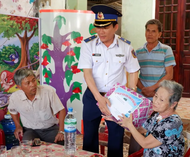 Cảnh sát biển tặng cờ Tổ quốc, trang thiết bị khám bệnh cho ngư dân Lý Sơn - Ảnh 4.