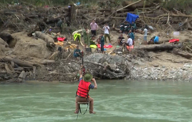 Lực lượng cứu hộ đu cáp treo vượt sông tìm kiếm người mất tích do sạt lở ở Quảng Nam - Ảnh 1.