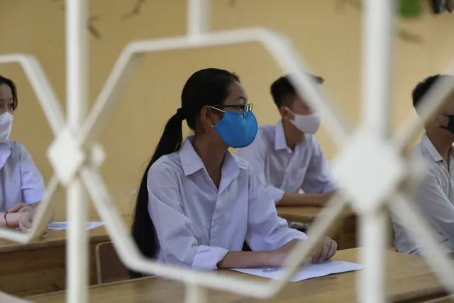 [Ảnh] Thí sinh đeo khẩu trang làm bài thi, phụ huynh hồi hộp chờ con vượt vũ môn - Ảnh 9.