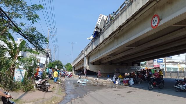 Tiền Giang: Xe tải chở cá lật ngang trên cầu, nhiều tấn cá vương vãi - Ảnh 1.