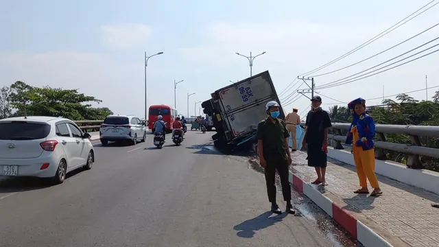 Tiền Giang: Xe tải chở cá lật ngang trên cầu, nhiều tấn cá vương vãi - Ảnh 3.