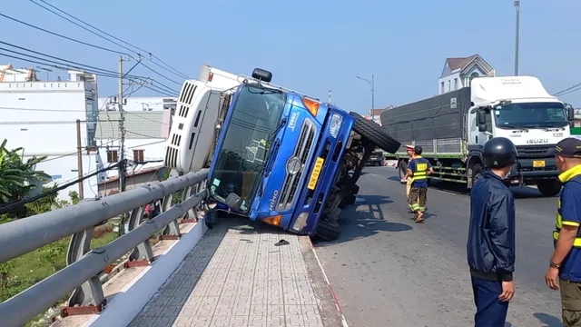 Tiền Giang: Xe tải chở cá lật ngang trên cầu, nhiều tấn cá vương vãi - Ảnh 4.