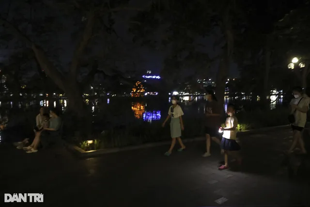 Hà Nội tắt đèn tiết kiệm điện, phố đi bộ hồ Gươm hoạt động trong bóng tối - Ảnh 1.