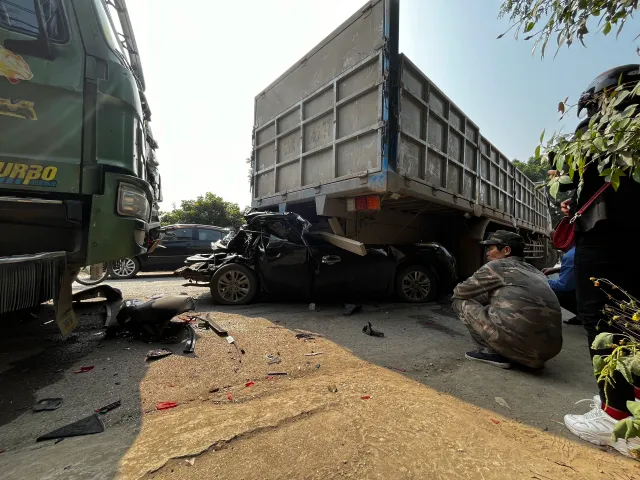 Ô tô con bẹp rúm dưới gầm xe tải sau tai nạn ở Hà Nội, 3 người thương vong - Ảnh 1.