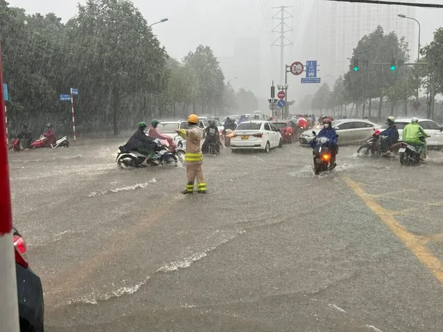 CSGT Hà Nội hướng dẫn người dân di chuyển an toàn trong mưa diông - Ảnh 1.