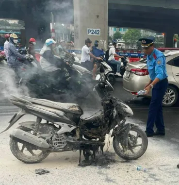 Xe máy đang chạy bất ngờ bốc cháy giữa ngã tư ở Hà Nội - Ảnh 1.
