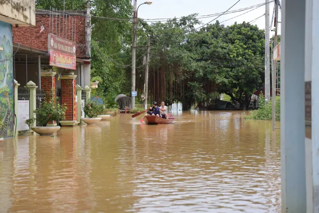 Hà Nội: Người dân thôn Bùi Xá di chuyển bằng thuyền do ngập - Ảnh 11.