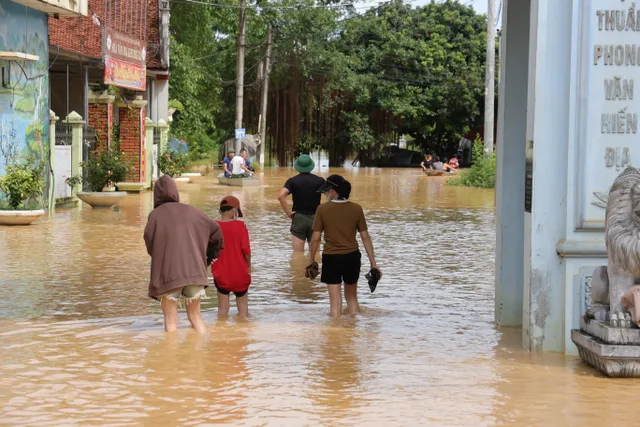 Hà Nội: Người dân thôn Bùi Xá di chuyển bằng thuyền do ngập - Ảnh 1.