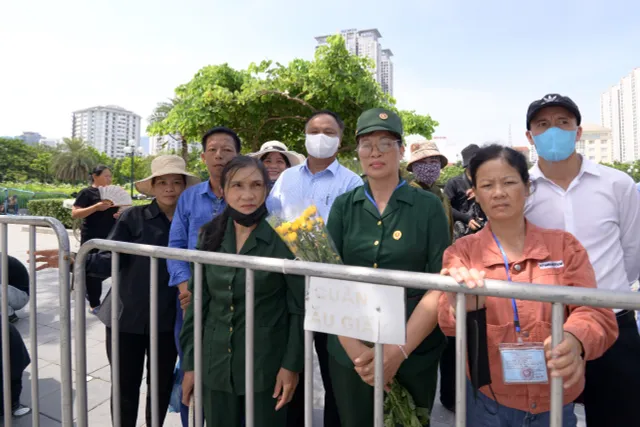 Dòng người đội nắng chờ tiễn đưa Tổng Bí thư Nguyễn Phú Trọng - Ảnh 1.