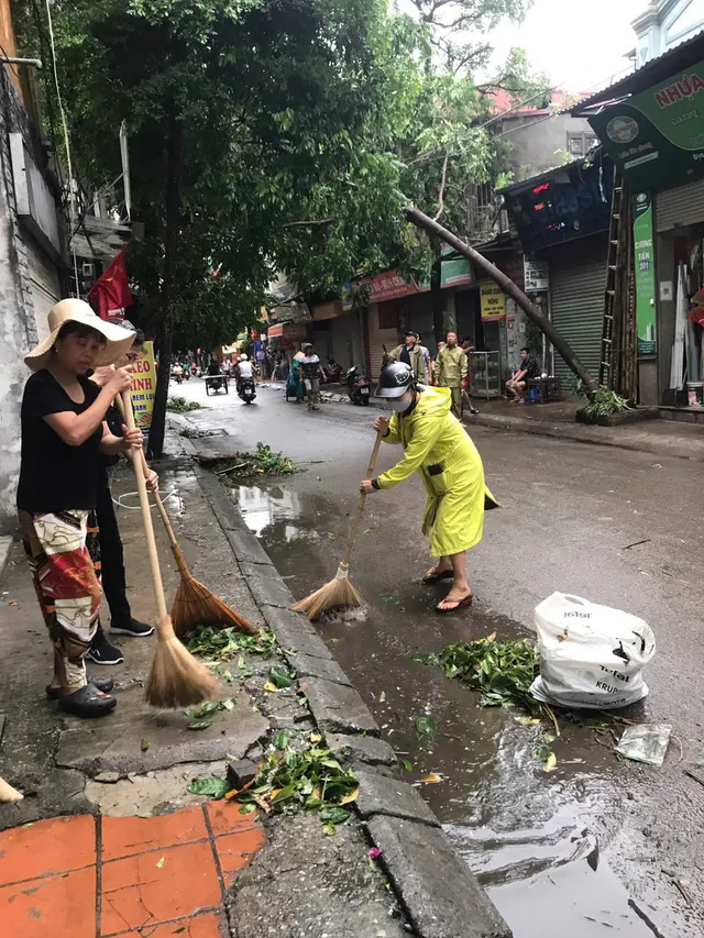 Người dân Hà Nội dọn dẹp đường phố sau cơn bão - Ảnh 2.