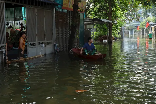 Nhiều hộ dân ở Hà Nội vẫn ngập trong biển nước, nguy cơ dịch bệnh bùng phát - Ảnh 1.