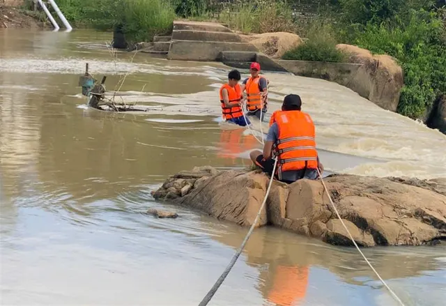 Cứu hộ 2 cháu nhỏ có nguy cơ bị nước cuốn - Ảnh 1.