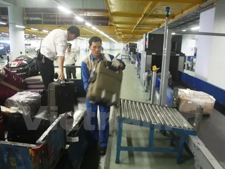 Noi Bai International Airport workers unload passengers' luggage at Terminal T2.