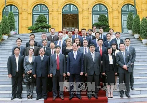 President Tran Dai Quang, Brunei Prince Pengiran Muda Abdul Qawi and businessmen pose for a joint photo in front of the Presidential Palace.